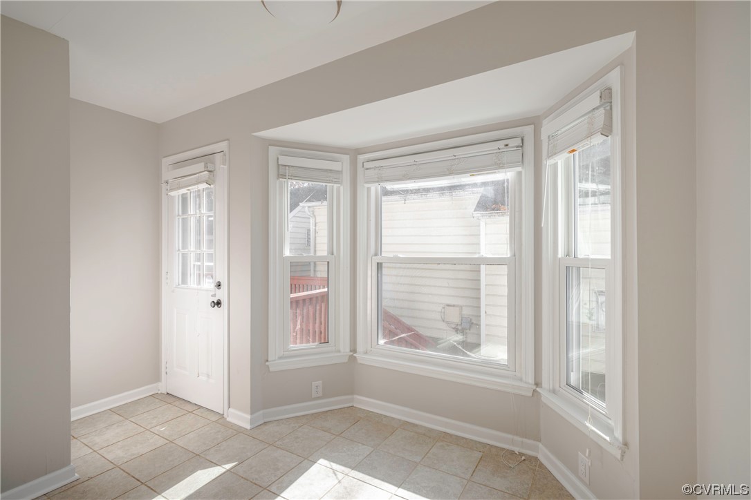 Doorway to outside featuring a wealth of natural light and light tile floors