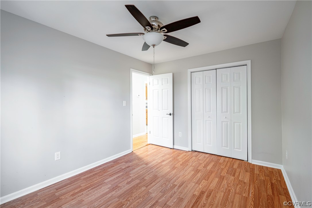 Unfurnished bedroom with light hardwood / wood-style flooring, ceiling fan, and a closet