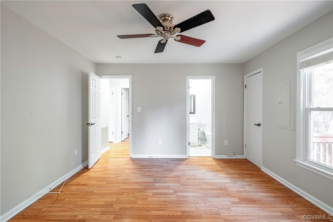 Empty room featuring a healthy amount of sunlight, light wood-type flooring, and ceiling fan