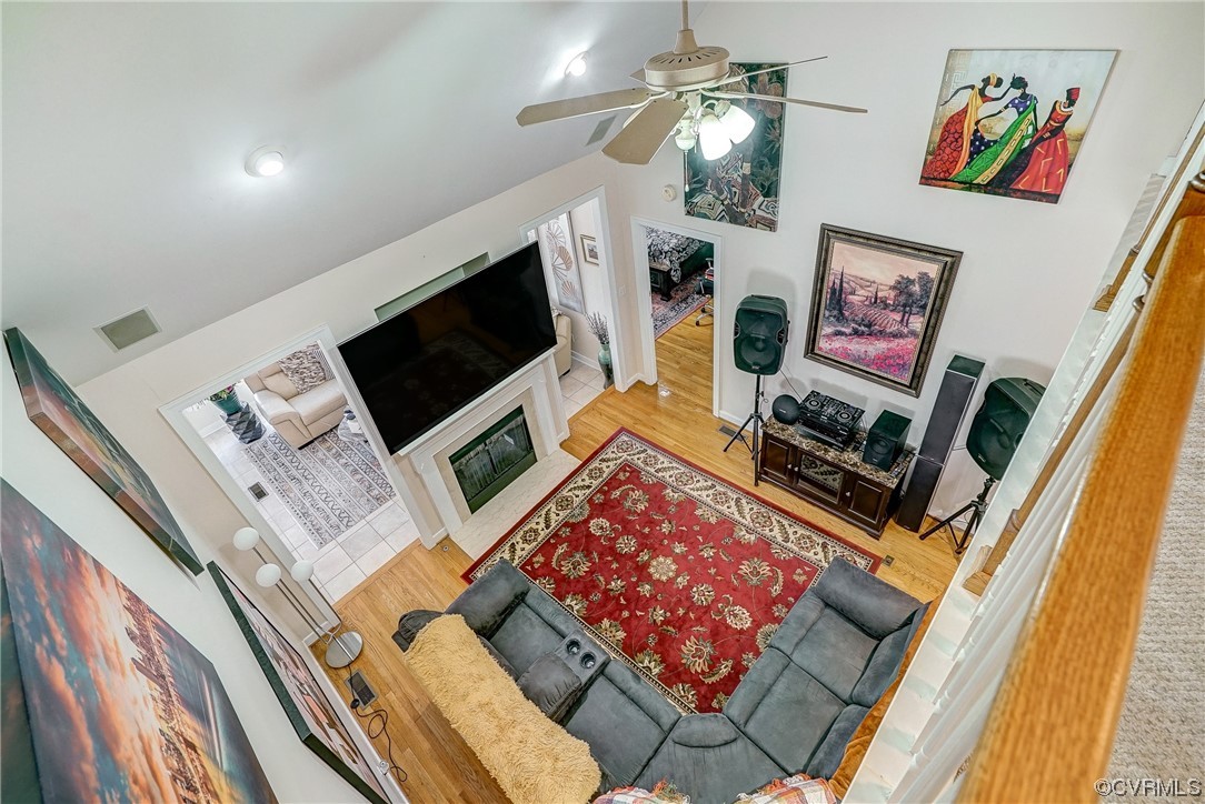 Living room featuring ceiling fan, high vaulted ceiling, and hardwood floors