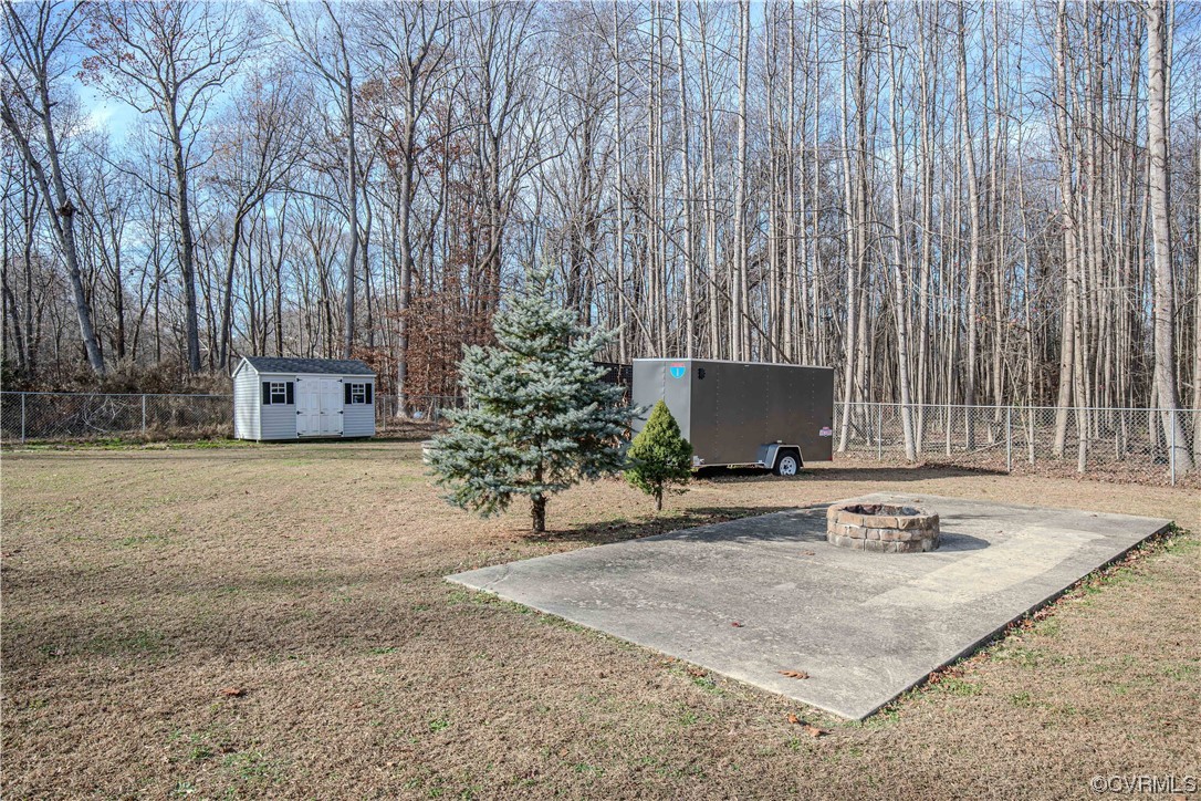 View of yard featuring a fire pit and a storage shed