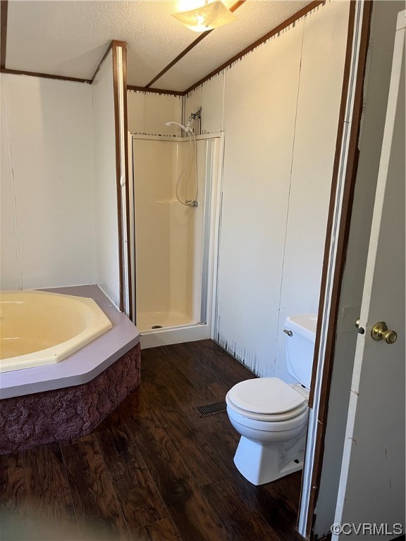 Bathroom featuring toilet, shower with separate bathtub, a textured ceiling, and wood-type flooring