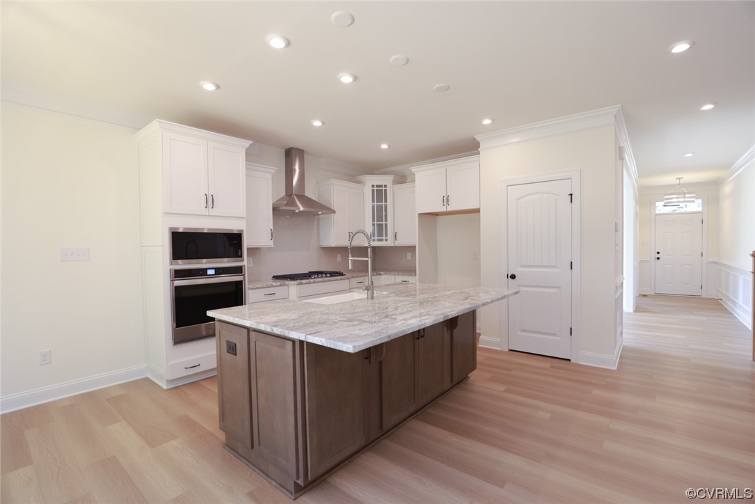 Large, inviting kitchen is open to the family room w/ gas fireplace &  features granite counters, wall oven/microwave, gas cooking, stainless steel range hood, large island w/ barstool area & pantry.