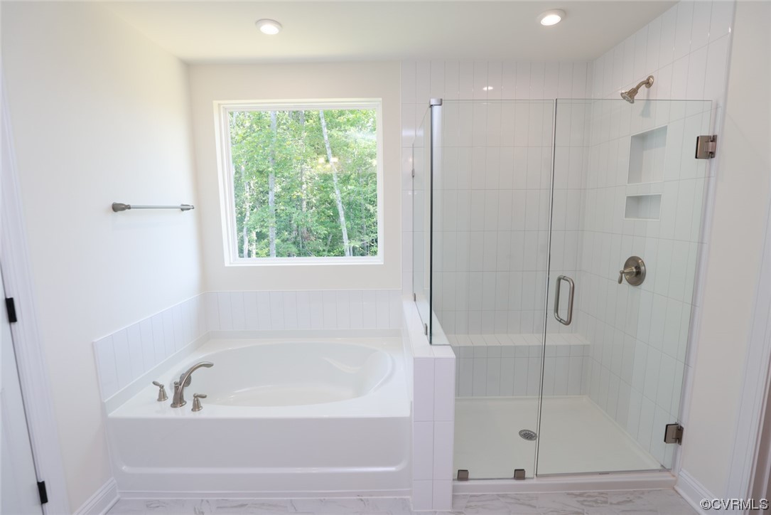 Primary bedroom w/ a large walk-in closet & a luxurious 5-piece bath w/ dbl vanity, frameless walk-in shower, soaking tub & water closet.