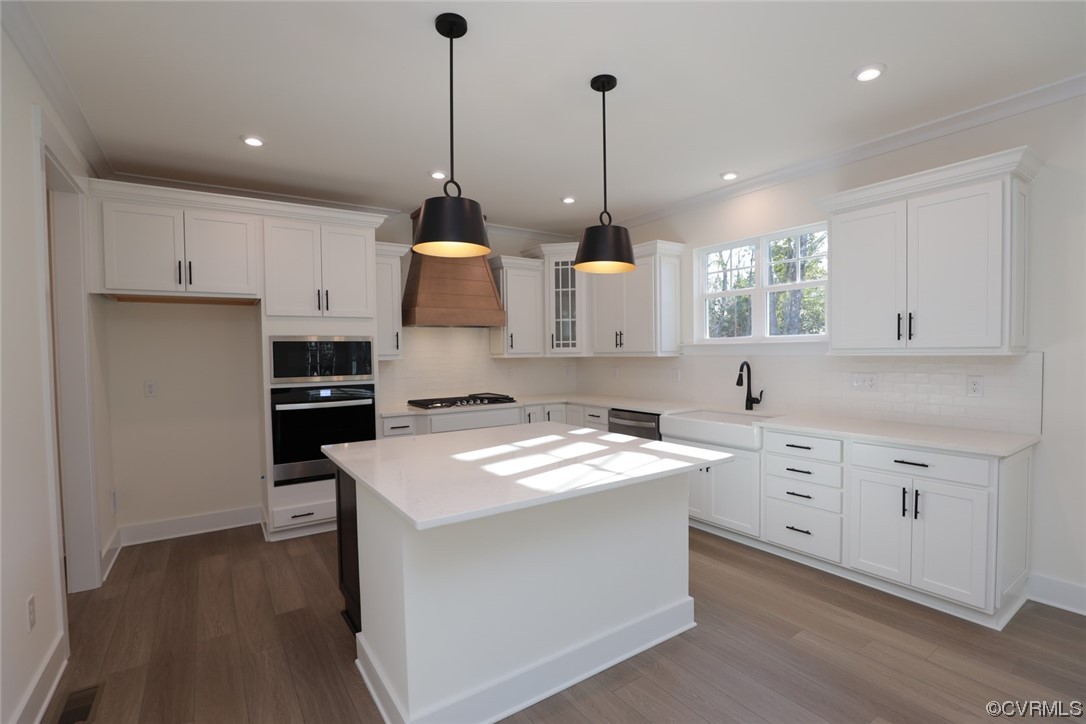 The designer CHEF’S KITCHEN features QUARTZ counters, wall oven/microwave, gas cooking, shiplap range hood, glass tile backsplash, center island w/ barstool area and a large pantry.