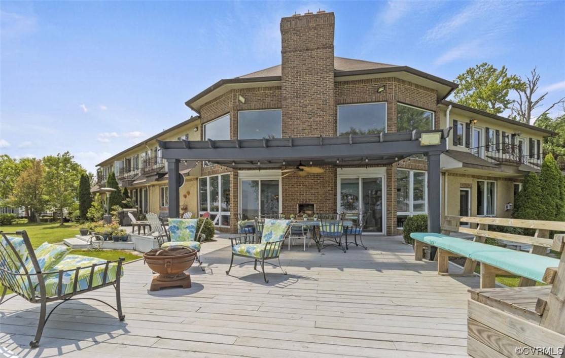 Back of property with a pergola, a fire pit, and a balcony