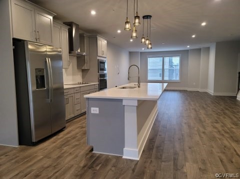 Kitchen featuring sink, appliances with stainless steel finishes, dark wood-type flooring, and wall chimney range hood