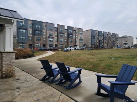 View of home's community featuring a patio area and a lawn