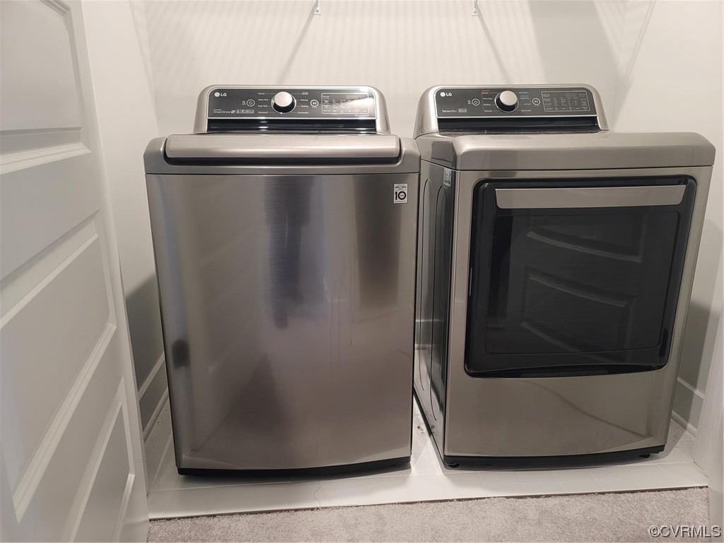 Laundry area featuring washer and dryer and light colored carpet