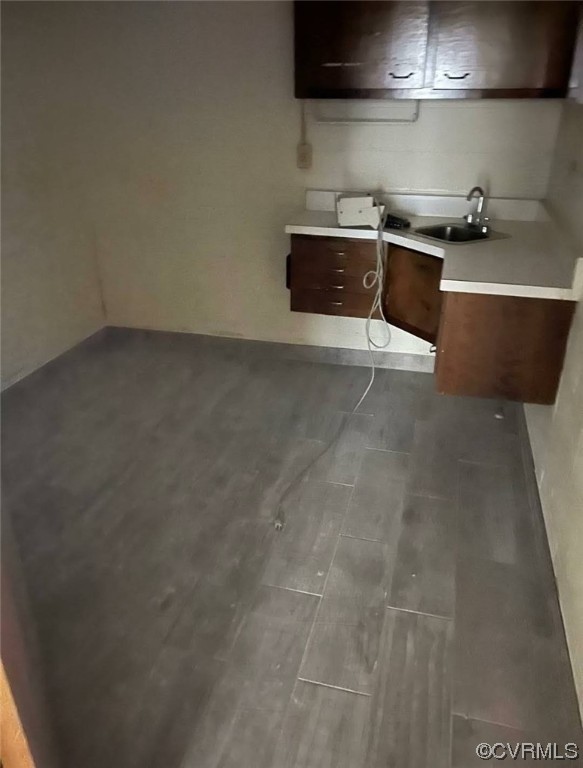 Kitchen with dark brown cabinetry, dark hardwood / wood-style flooring, and sink