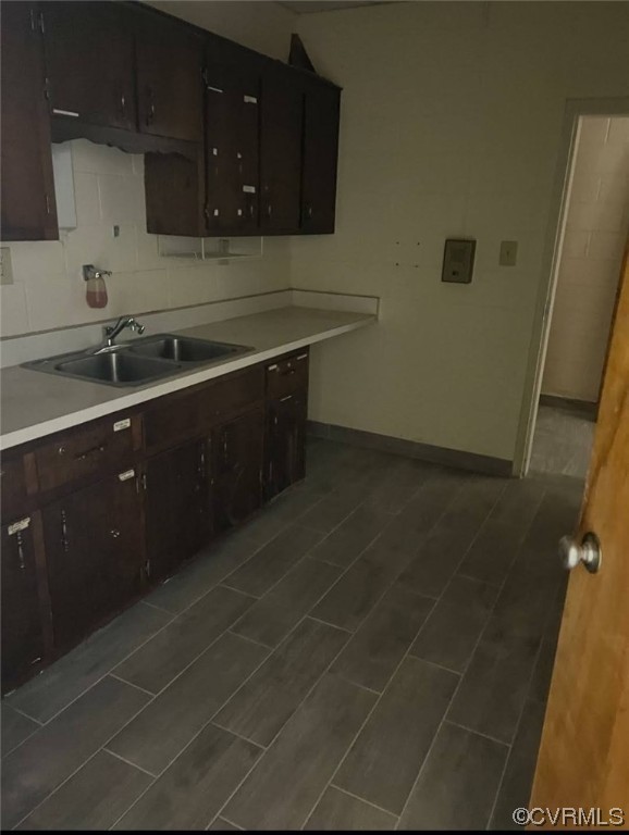 Kitchen with dark brown cabinets, sink, and backsplash