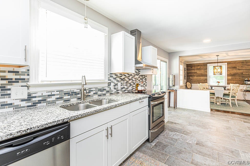 Kitchen featuring white cabinets, sink, pendant lighting, and stainless steel appliances