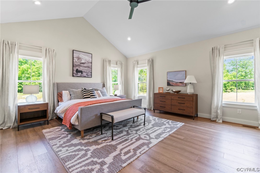 Bedroom with ceiling fan, high vaulted ceiling, and light hardwood / wood-style floors