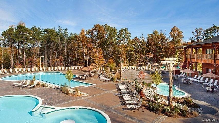 View of swimming pool with a patio and a hot tub