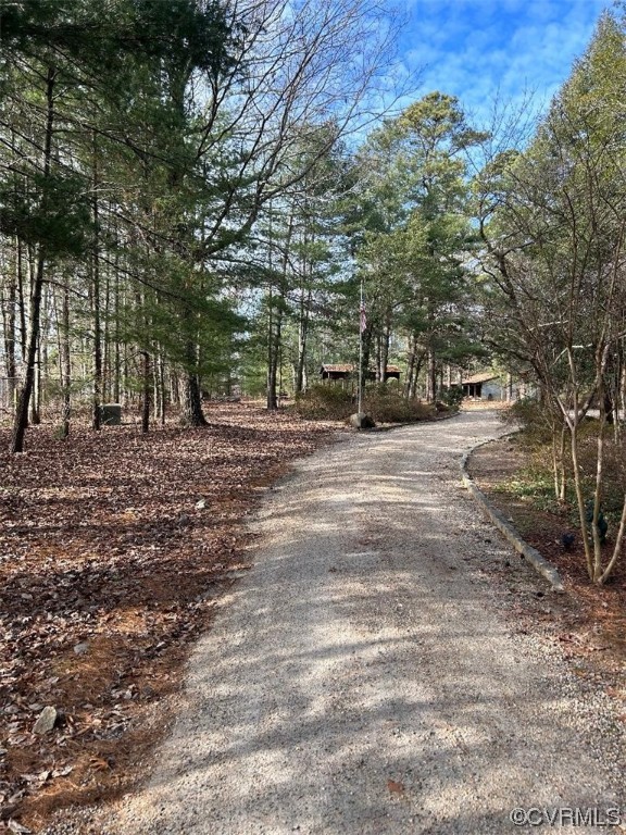 View gravel road...house on the right is not for sale and is occupied.  The road/driveway to lots 2 and 3 will travel to the left between the trees where there are leaves.   The road will be wider and not part of neighbors driveway