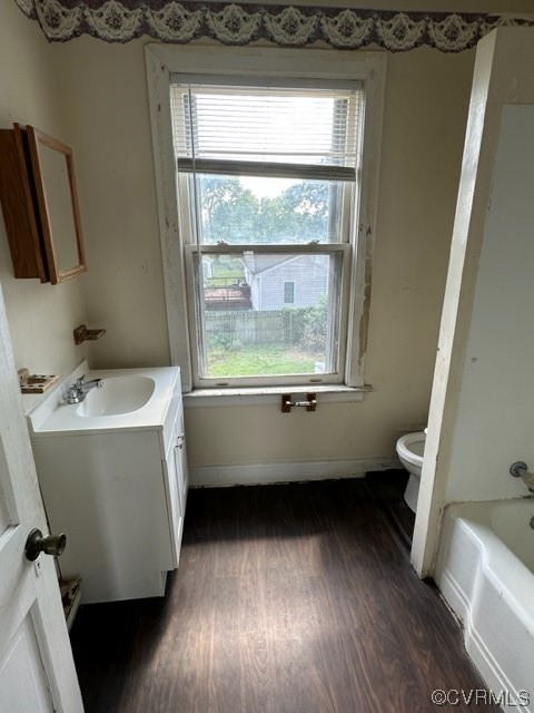 Bathroom with toilet, vanity, and hardwood / wood-style flooring