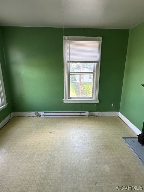 Unfurnished room featuring a baseboard heating unit