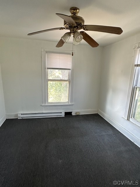 Unfurnished room with a healthy amount of sunlight, ceiling fan, a baseboard radiator, and dark colored carpet