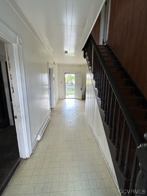 Corridor featuring light tile floors and a baseboard heating unit