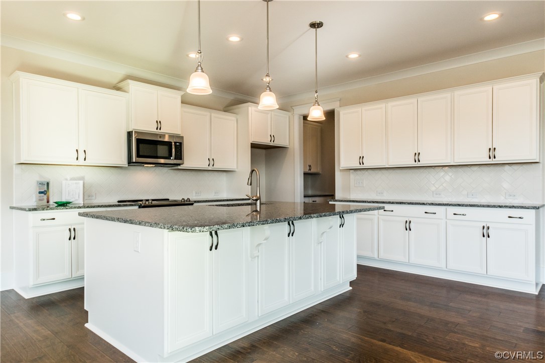 Photo represents the plan, not the actual home. Design selections may vary. DESIGNER kitchen, ideal for entertaining, features an island, quartz counters, Butler's pantry, gas cooking, wall oven, SS appls, kitchen backsplash and LED recessed lighting.