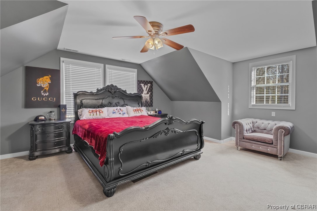 Bedroom featuring lofted ceiling, light colored carpet, and ceiling fan