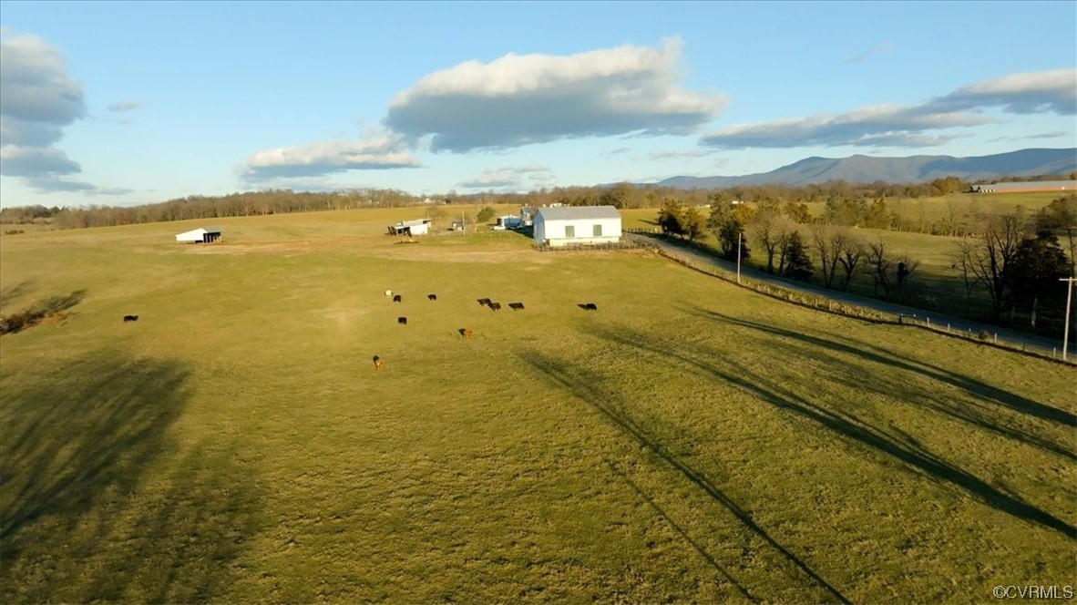 Surrounding community with a rural view, a yard, and a mountain view