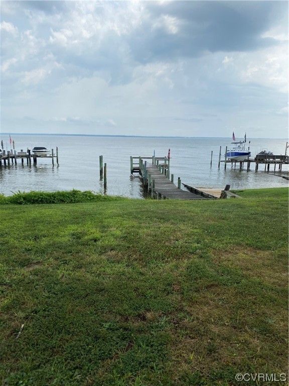 Dock area featuring a water view and a lawn