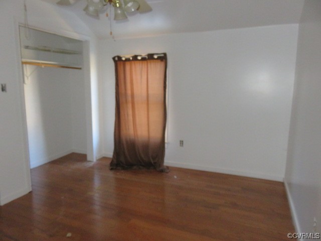 Unfurnished bedroom featuring dark hardwood / wood-style flooring and ceiling fan