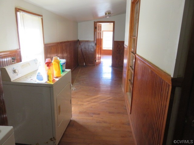 Laundry room with washing machine and dryer and light hardwood / wood-style floors