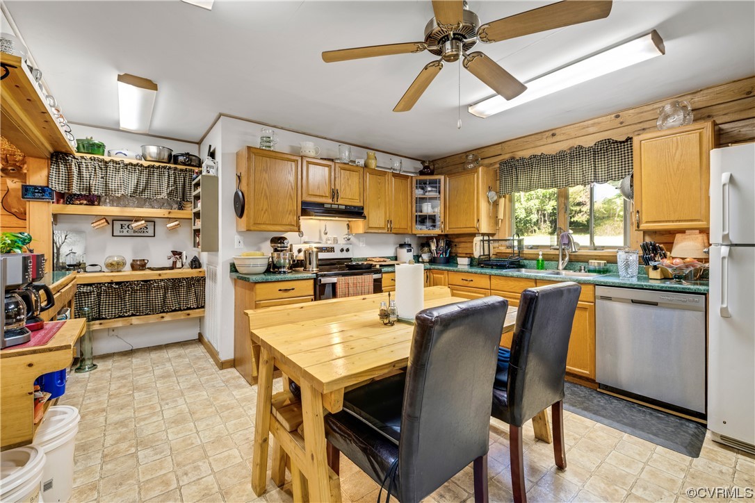 Kitchen featuring light tile floors, stainless steel appliances, ceiling fan, and sink