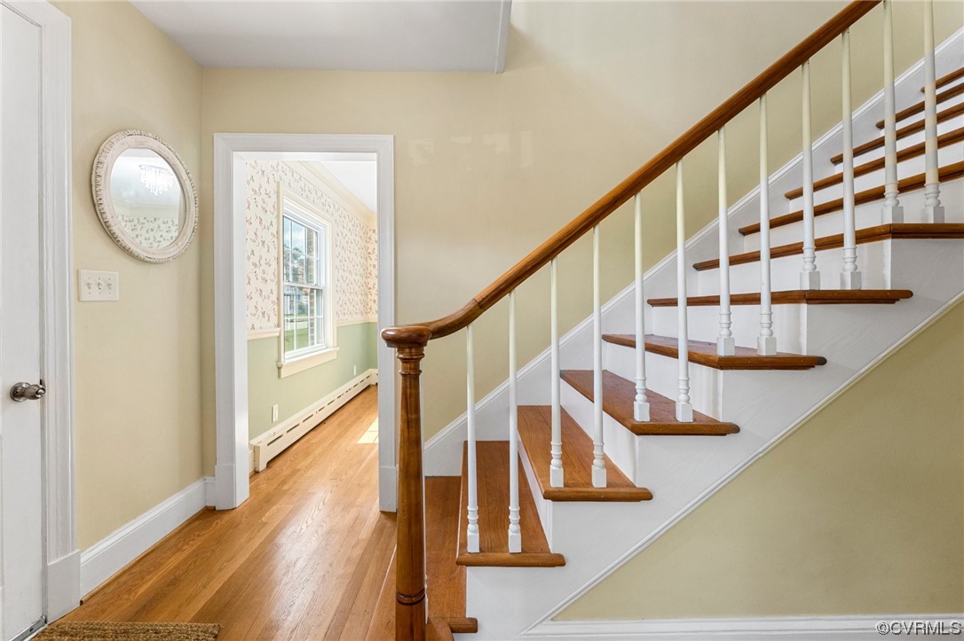 Stairs featuring light hardwood / wood-style flooring and baseboard heating