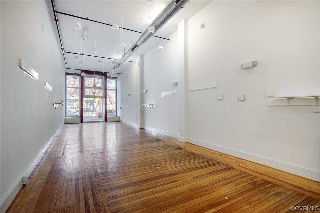 Unfurnished room featuring light hardwood / wood-style flooring and a high ceiling
