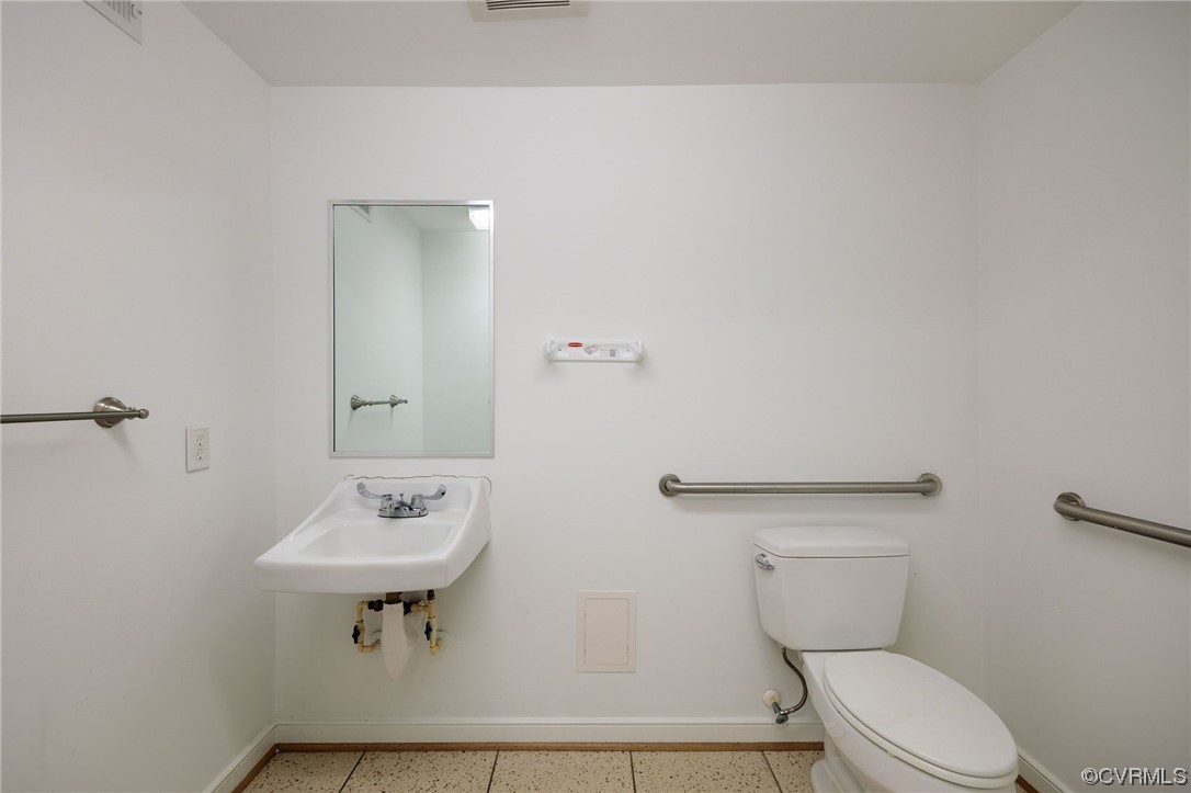 Bathroom featuring sink, tile flooring, and toilet