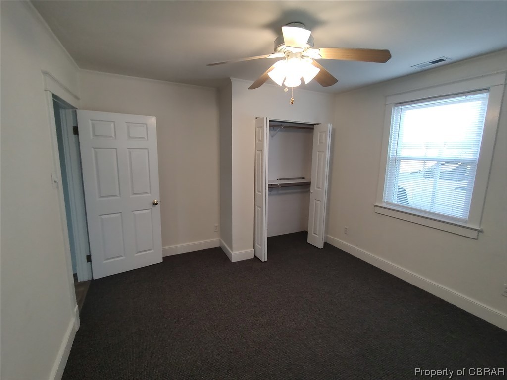 Unfurnished bedroom with  new carpet, ceiling fan, and a closet