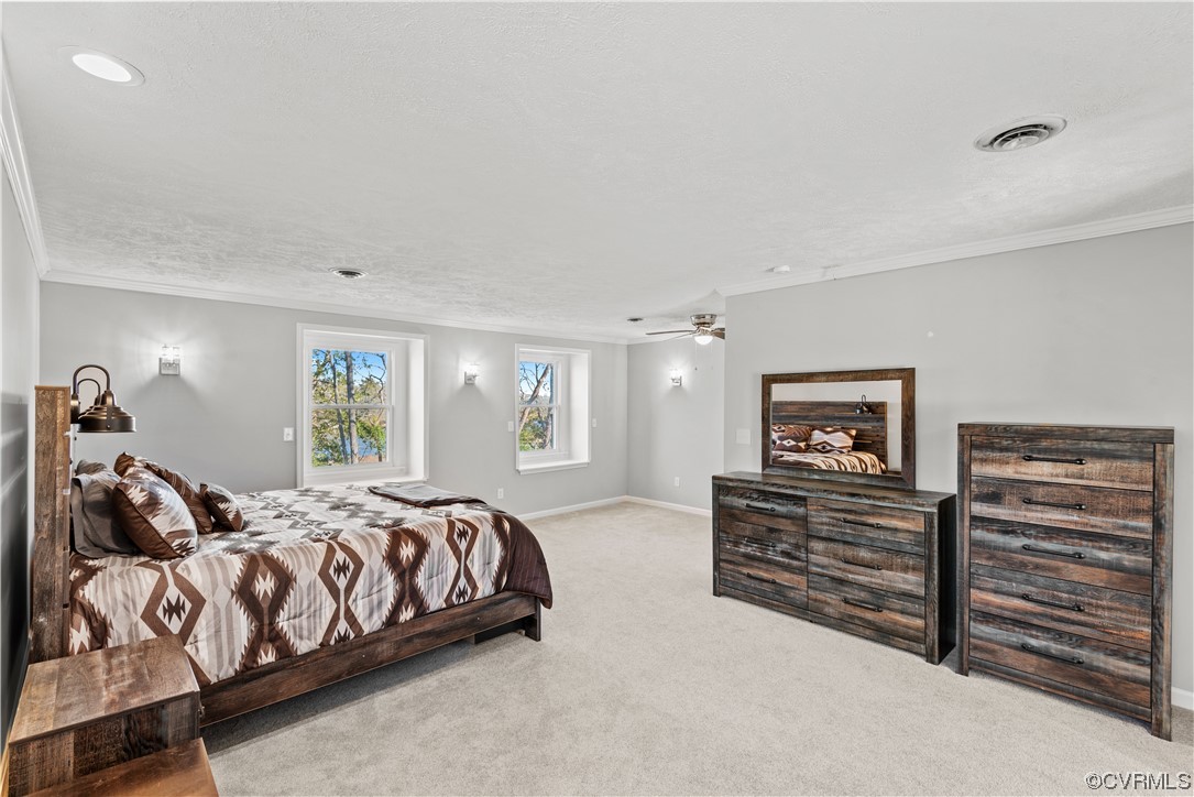 Carpeted bedroom featuring ornamental molding and ceiling fan