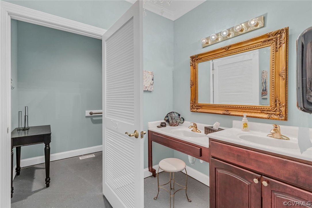 Bathroom featuring crown molding and dual bowl vanity