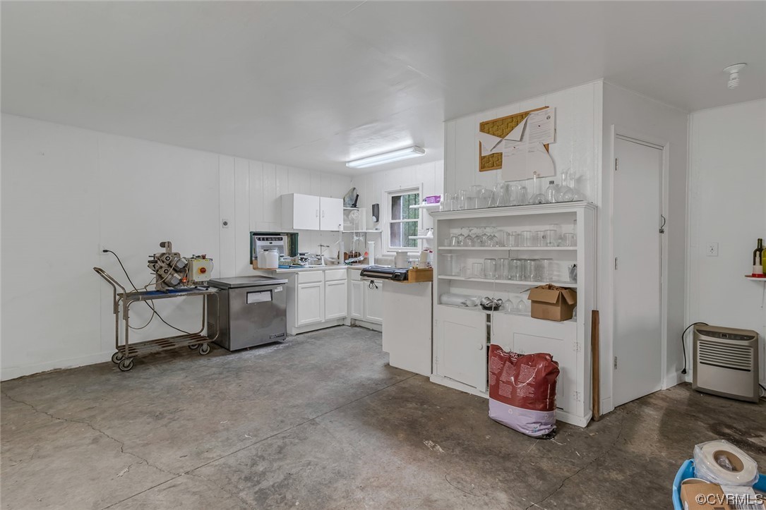 Kitchen with white cabinetry and concrete floors