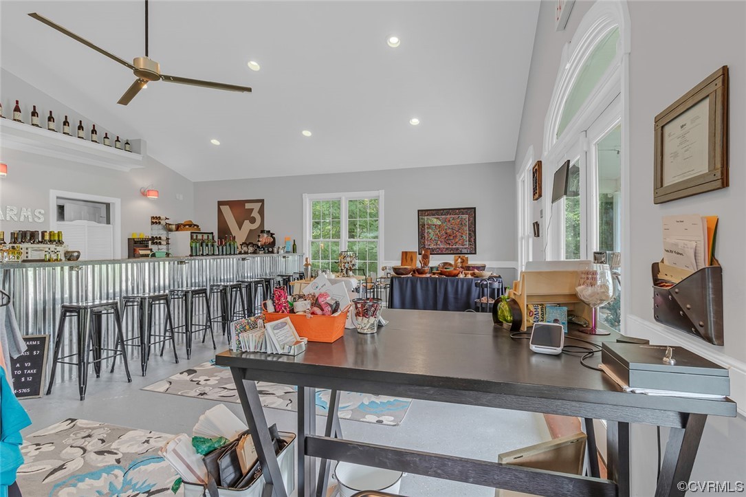 Dining area with ceiling fan and high vaulted ceiling