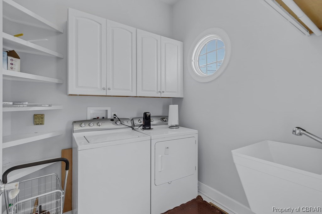 Clothes washing area with washer and dryer, cabinets, sink, and washer hookup