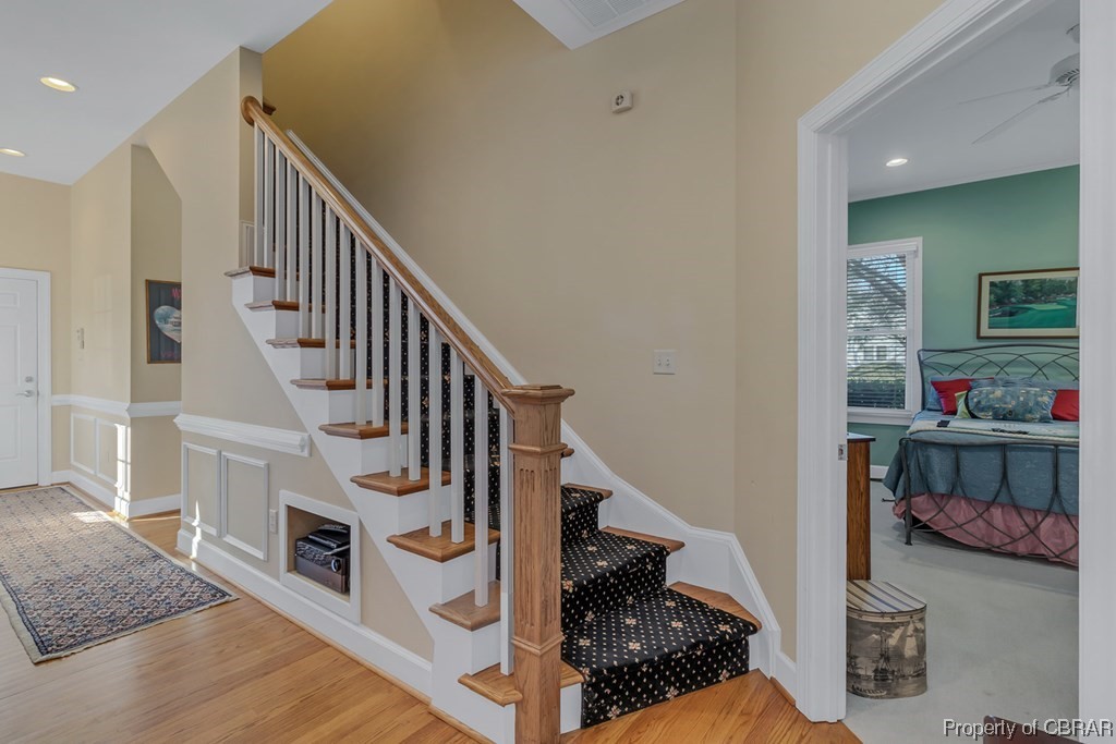 Staircase with light hardwood / wood-style flooring and ceiling fan