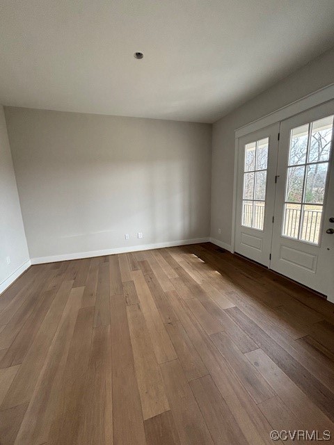 Empty room with hardwood / wood-style flooring