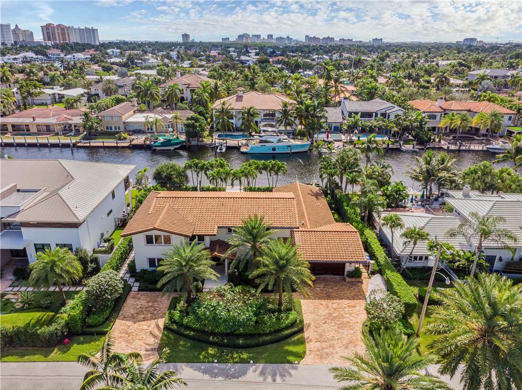 Tropical Paradise on an oversized lot with 100 feet of Waterfront in the heart of Coral Ridge. This Move-In Ready Pool Home boasts a large chef's kitchen, wine room and lushly landscaped yard that is perfect for entertaining. Park your boat out back, and enjoy all that South Florida has to offer. Large Primary Suite with attached Den/Office on second floor. Large Guest Suite on first floor perfect for in-laws. Impact windows and doors throughout! Highly Desirable Bay View School District. Short walk or bike to the beach.