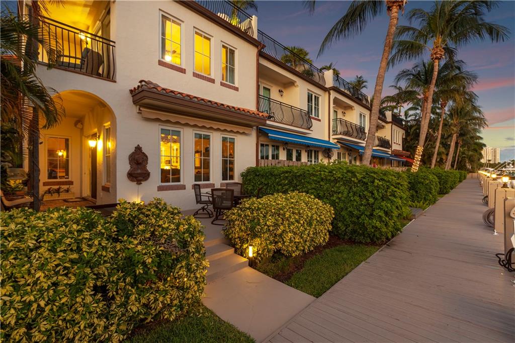 Embrace the S. Florida dream in this deep waterfront townhome boasting 42' of dockage, a large turning basin & no fixed bridges to the Ocean. This corner unit provides an abundance of natural light & vol. ceilings that enhances the open flr plan. Enjoy the tropical lifestyle with a 1st flr covered & open patio area overlooking the waterway. Breathtaking sunrises & the most memorable sunsets are experienced over the downtown skyline from the oversized roof top terrace. Enjoy intimate gatherings in the formal living room & dining area or casual times in the open kitchen that overlooks the breakfast & family room. The primary suite features 2 walk-in closets, a lavish bathroom & private balcony. The loft area/home office, 2 guest bedrms & laundry rm complete the 2nd floor. Sq ft from Imapp.