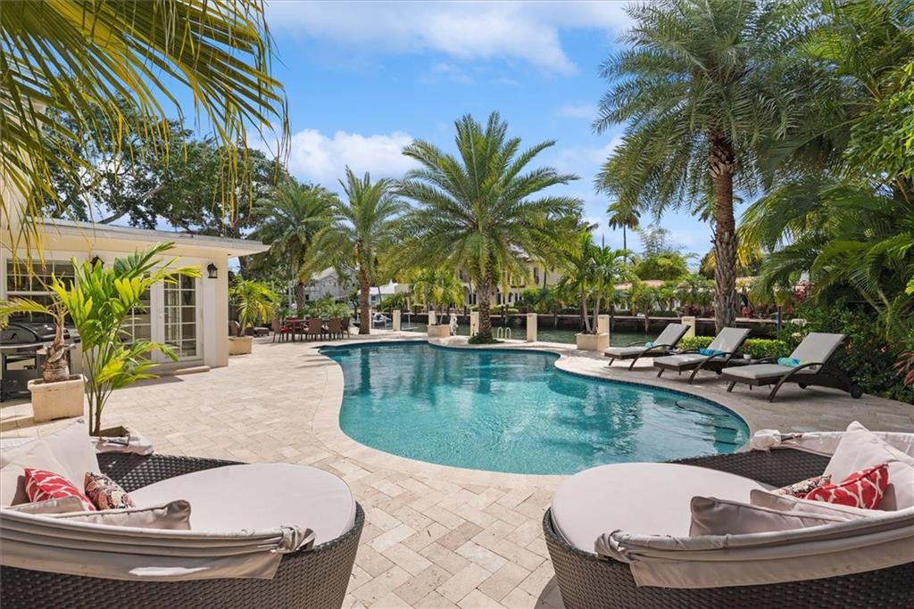 Lovely deep-water pool home in South Las Olas Isles. On a wide canal, boasting a 100’ cement dock, travertine patio areas and a luxurious free-form pool, the outdoor living spaces prove inviting. Renovated in 2011 with a full master suite added in 2015. All 4 bedrooms enjoy wood floors, walk-in showers found in 2 of the 3.5 baths. Living spaces plus the dedicated office space are tiled. French doors and Plantation shutters deliver a light, bright home. Ample storage with 6 cedar-closets, 2 walk-ins plus a built-in laundry room. A 2-car garage and circular drive compliment the exterior design and landscape of the one-level home. HVAC, electric, tankless hot water, plumbing, pool heater and equipment updated in renovations. Up to 90’ yacht dockage -1.1 miles to Ft. Lauderdale Beach!