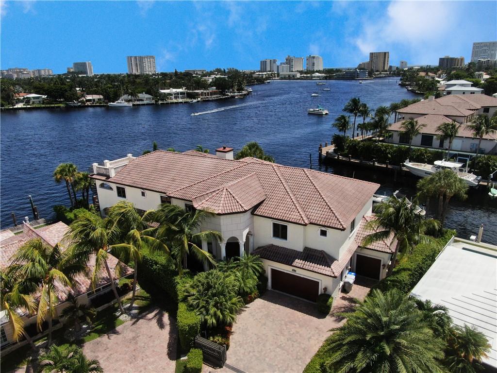 An irreplaceable location. Pompano Beach introduces 750 SE 22nd Avenue, a luxurious home surrounded by 232' of ocean access waterfront in Lake Santa Barbara's no wake zone. Enter the property to volume ceilings. 6 bedrooms, 6.5 bathrooms, Elevator, & 2 bonus den rooms, ample space for multiple purposes, including home offices, study areas, and more. Oversized master bedroom, bathroom and balcony. Relax & enjoy the Florida sunshine in your private tropical backyard featuring a vast heated pool with fountains, sun shelf & spa with lake and turfed greenery views. Outdoor showers, surround sound speakers, Gourmet summer kitchen and 3rd-floor sun lounge with views of sunrise and sunset. 3-car garage. Beautiful open great room, formal dining room.