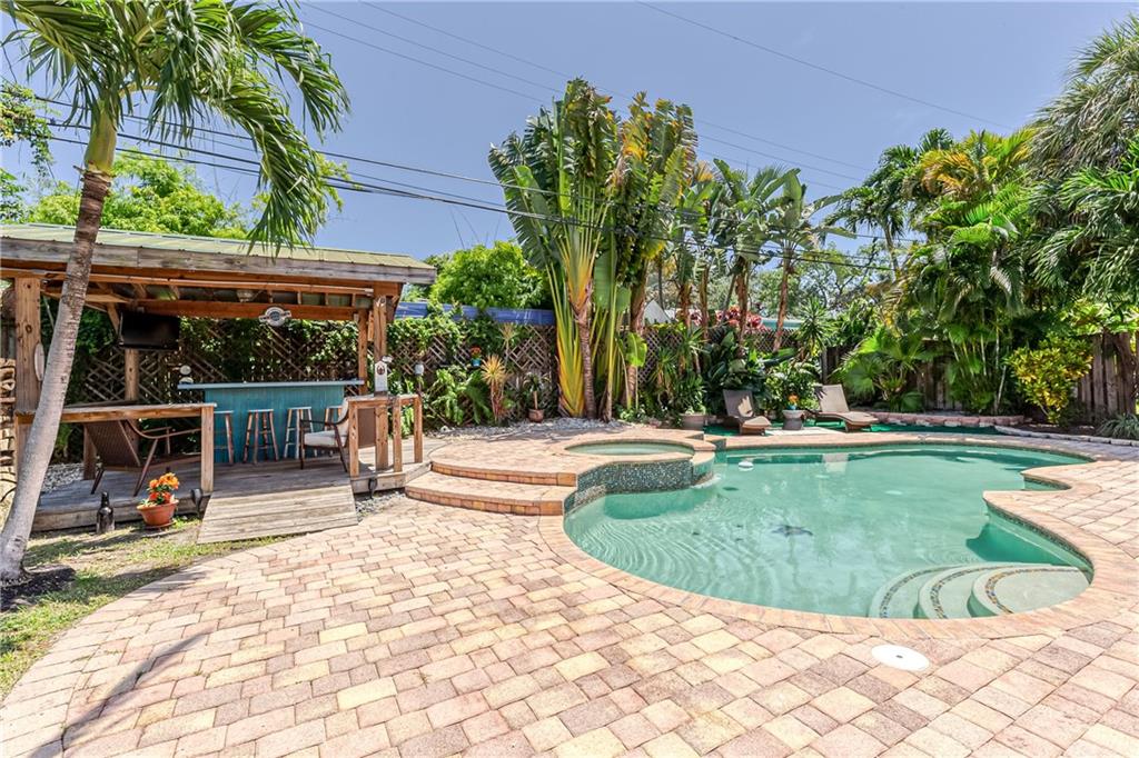 Island Style Oasis in East Pompano Beach! This 3 Bedroom 2 Bath 1 car garage home has an incredible backyard with freeform pool, heated spill in Spa & Tiki Bar for Entertaining Friends & Family. Beautiful Updated Kitchen w/ wood Cabinets, Granite Counters & Stainless Appliances. Both Bathrooms have been updated with Wood Cabinets, Tile & Granite. Home has Laminate Wood Flooring & Ceramic Tile throughout. The property boasts Natural Gas which is rare for South Florida, w/ Tankless Water Heater, Pool Heater & BBQ Grill. Newer Air Conditioning System was replaced in last two years. Property has easy access to Highways, Popular Dining, Entertainment, Shopping, and the Ocean is less then 1.5 Miles from your doorstep. Located in the Heart of Pompano's Hot Redevelopment Area, this is a Must See!