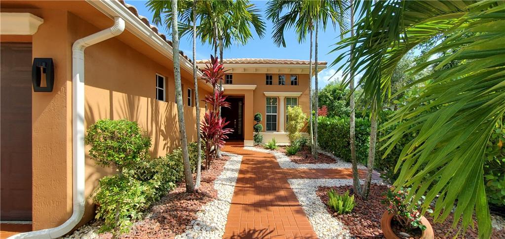 Beautiful entryway lined with lush landscaping