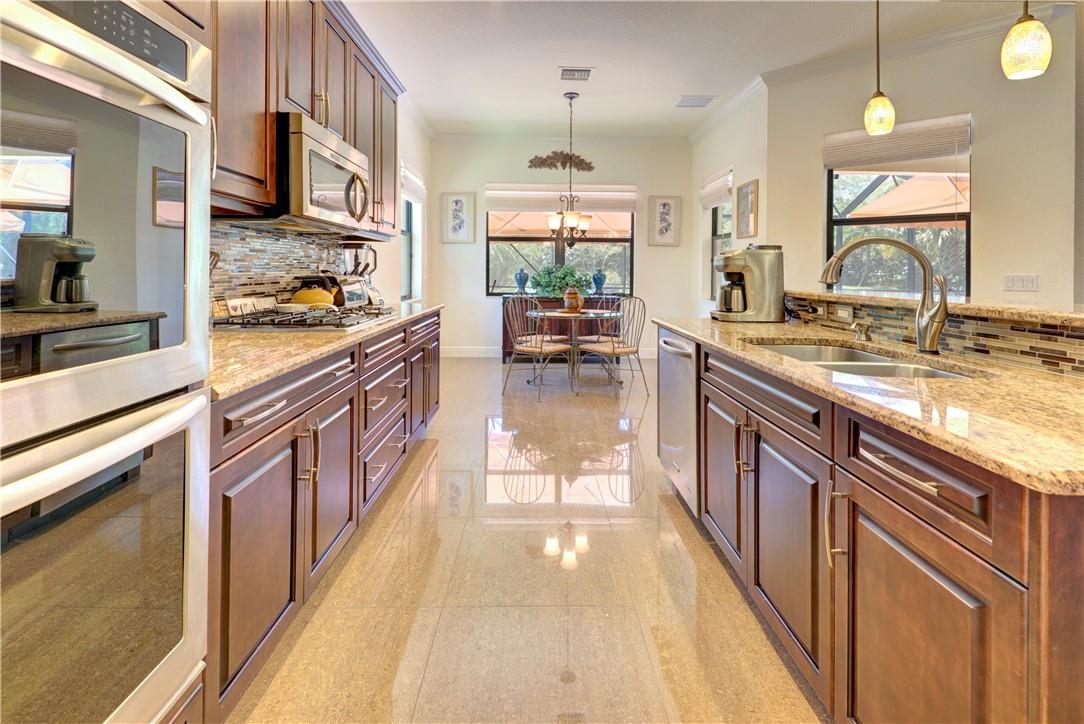 Wow! Large & open 3 bedroom PLUS DEN (used as 4th bedroom) 3.5 bath Cottonwood Model newer build home in Heron Bay just steps to the clubhouse! The home has an ENORMOUS screened in extended paver patio enclosure with awnings AND summer kitchen (about $50K in upgrades)! HURRICANE IMPACT WINDOWS, energy efficient appliances, natural gas, crown molding, tank-less water-heater, wired for surround sound, custom fit blinds, upgraded landscaping, corner lot & custom closets! Low HOA fee!