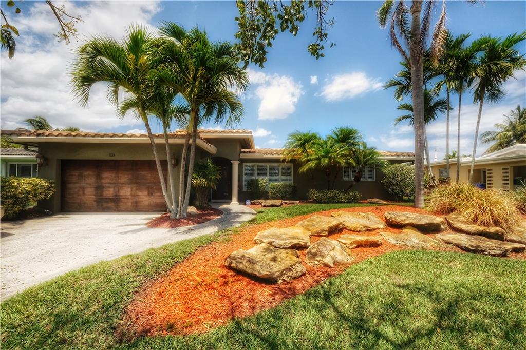 Feel the warmth and charm of this updated waterfront home located in East Pompano Beach!!!
As you immediately enter the front door you are welcomed by a formal living room featuring a double sided wood burning fireplace.  
The 18" travertine floor will then guide you through the remodeled kitchen with granite counter tops into a HUGE second living room combined with a large dining area, fireplace, and spacious laundry room. The 2 sets of double doors open onto to a brick paver patio leading to a commercial grade CONCRETE seawall built to todays current building code along with a 10,000 boat lift.  
The spacious master suite offers a remodeled bathroom tastefully finished with an oversized shower, large walk in closet, and double doors opening to a small deck. NO HOA!!! Additional features include custom crown molding throughout, whole house generator, plumbing for a backyard barbeque or firepit, storm shutters, and two car garage with built in cabinetry.