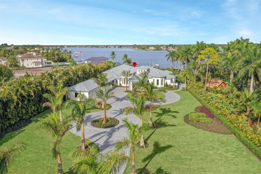 As you pull into the private gates of 5695 Pennock Point, you are immediately welcomed to your expansive riverfront estate by the palm tree lined double circular driveway. The home, which was originally built by Neandross Builders, has been completely reimagined, redesigned and totally reconstructed from top to bottom by the highly renowned builder, Onshore Construction. Some of the many features include volume ceilings, floor-to-ceiling new impact windows with sweeping views of the Loxahatchee River, extensive custom cabinetry and built-ins, spacious formal living and dining rooms that flow gracefully into the stunning chef's kitchen, family and bar/club rooms and so much more.